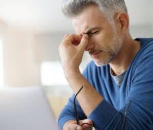 man pinching nose in pain