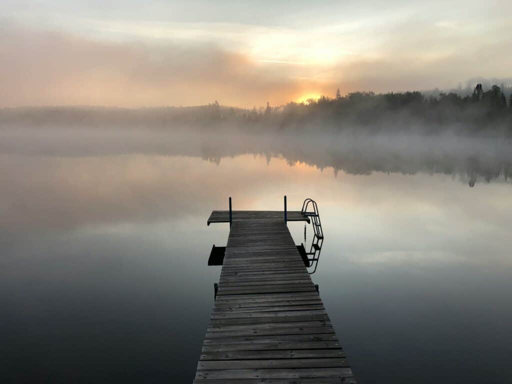 gray wooden pallet sea dock with fog
