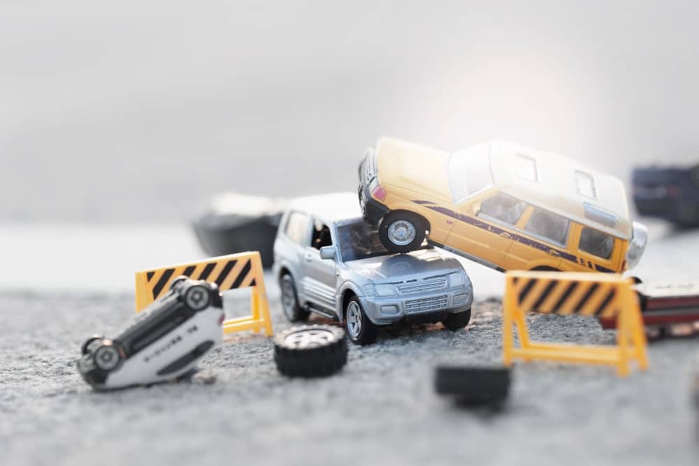 Scene of cars (miniature, toy model ) accident on street construction zone.