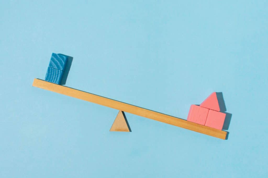 balance with blue blocks on one side and red blocs on the other side.