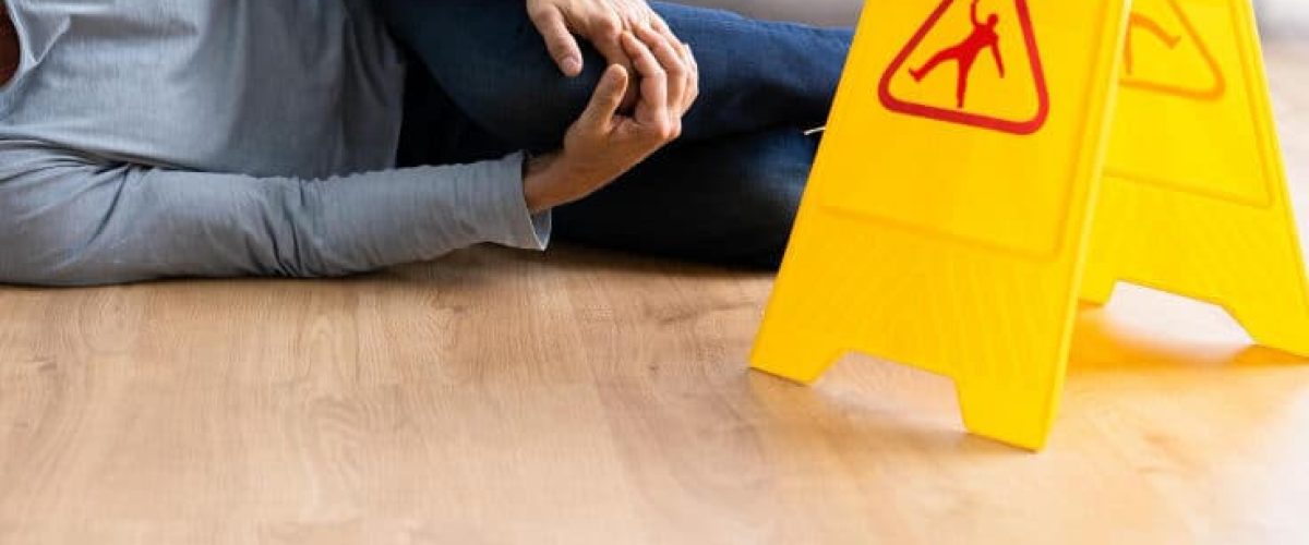man hurt with wet sign caution sign next to him