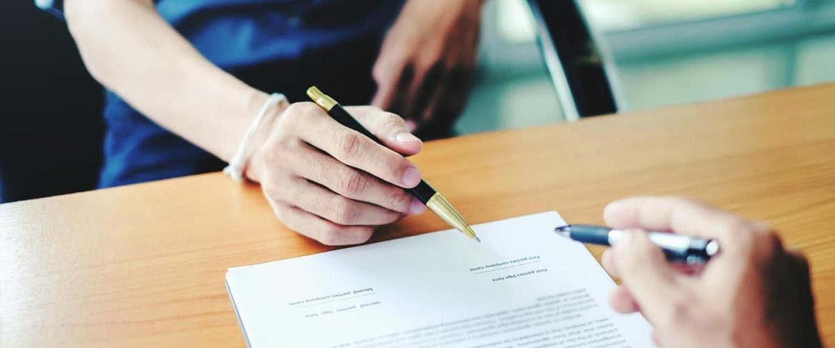 Midsection of woman holding paper while sitting on table