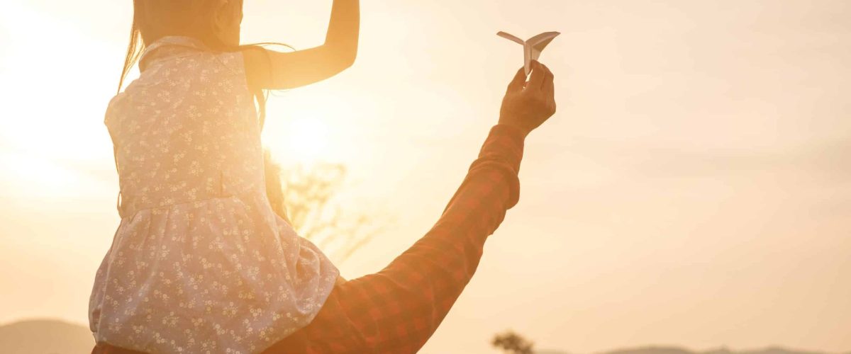 Father and daughter holding paper rockets