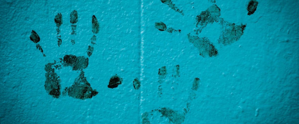 Image of black fingerprints on a blue wall